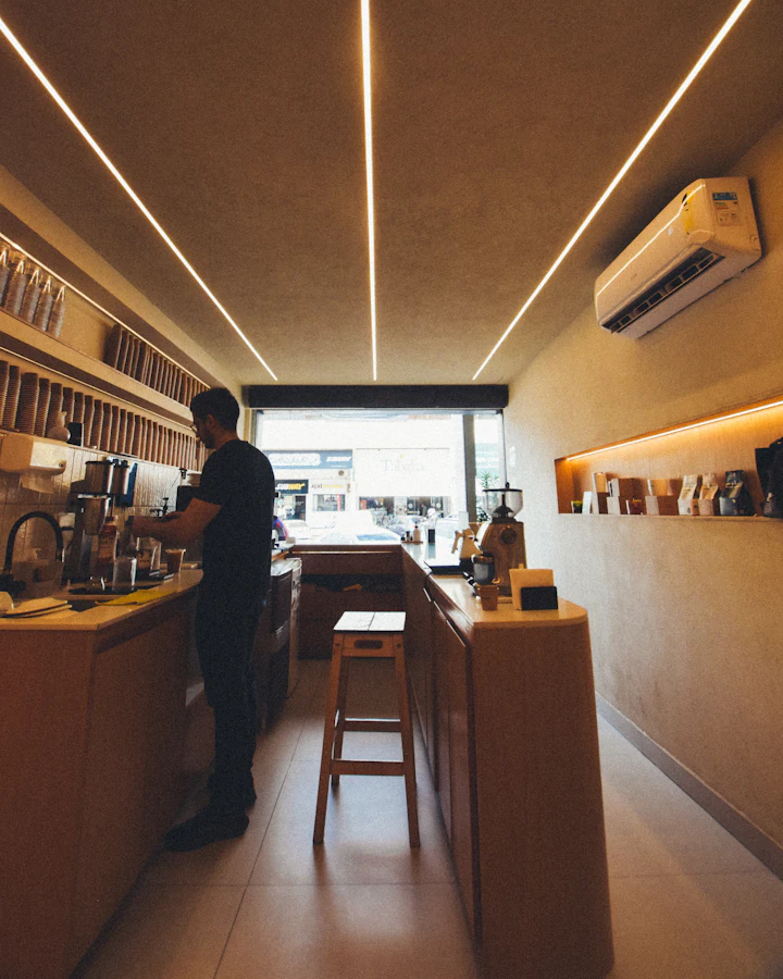 Barista making coffee behind a long wooden counter